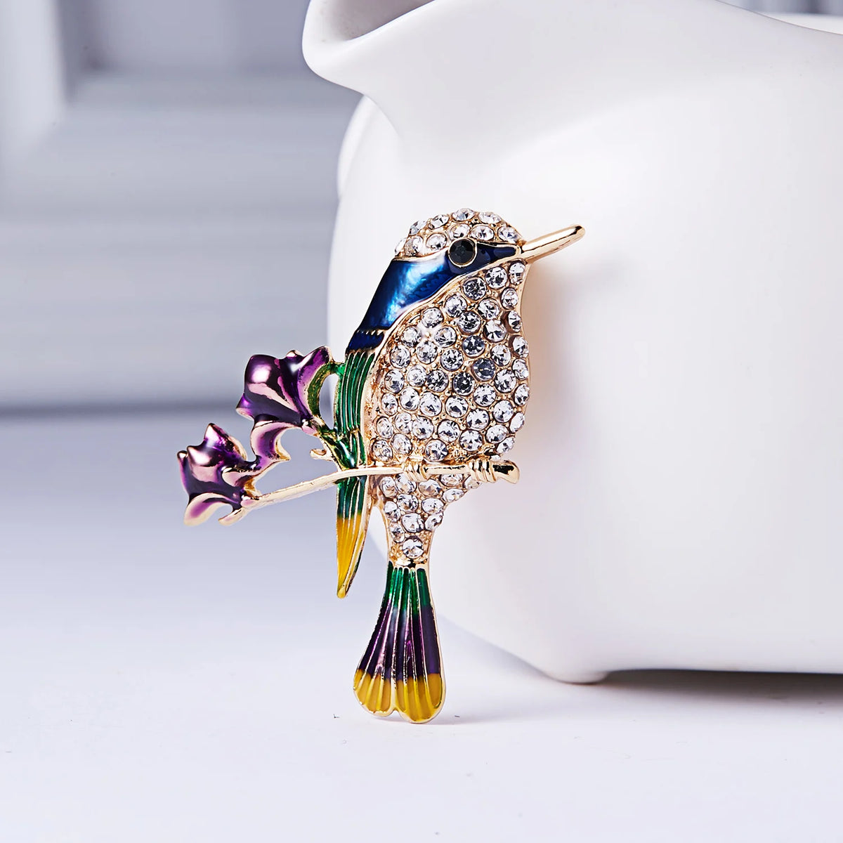 The Jewelled Kingfisher Brooch on a white cushion