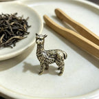 Alfie the Alpaca bronze figurine on a white plate