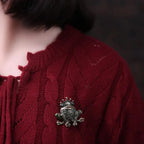The Frog Prince Brooch worn on a red knitted cardigan