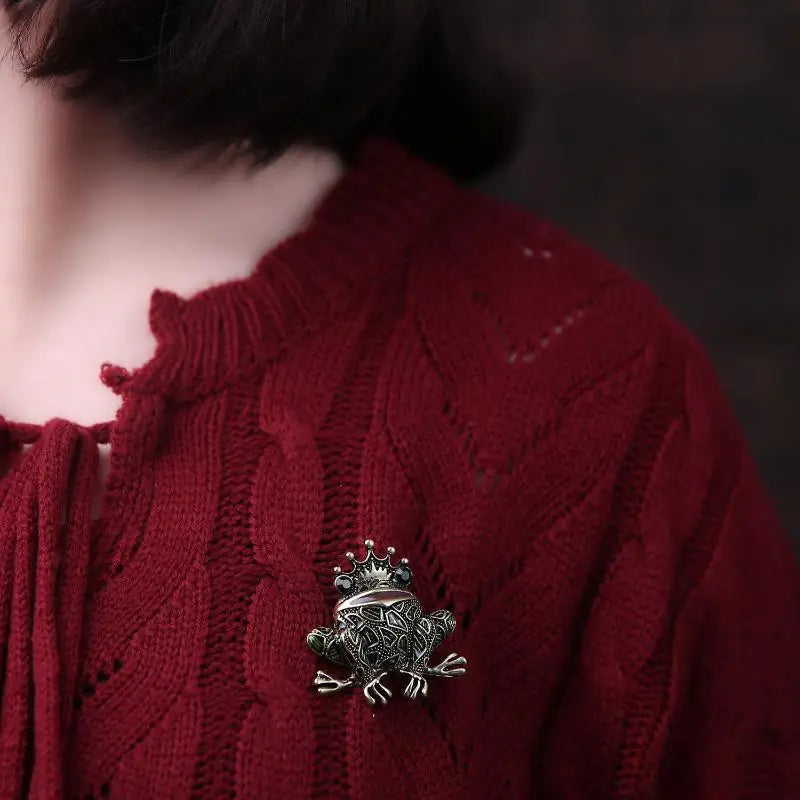 The Frog Prince Brooch worn on a red knitted cardigan